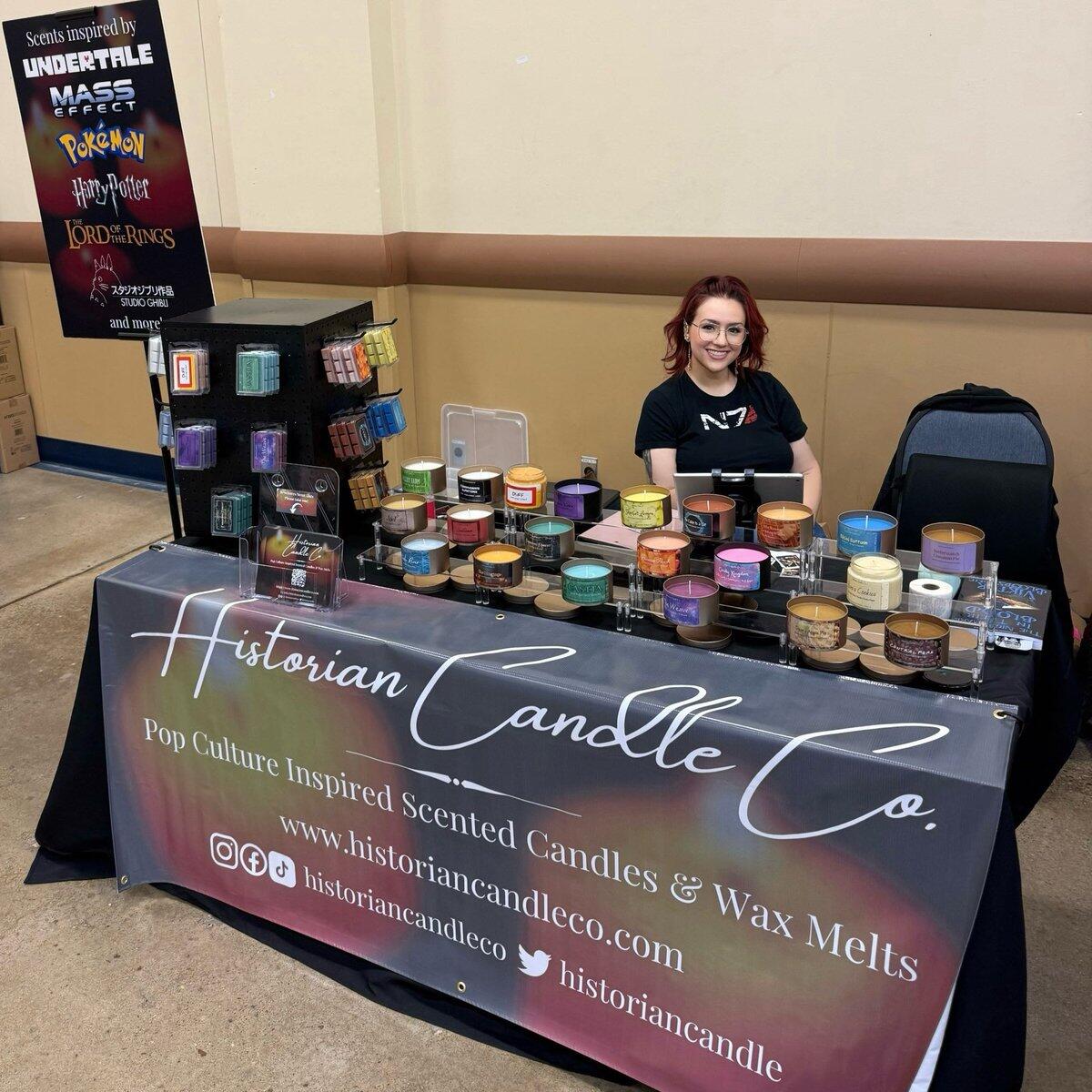 Amanda at the Historian Candle Co. booth at Steel City Con, surrounded by candles and wax melts